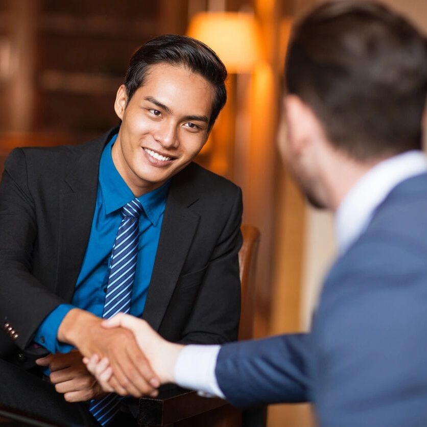 Two men shaking hands in a restaurant.